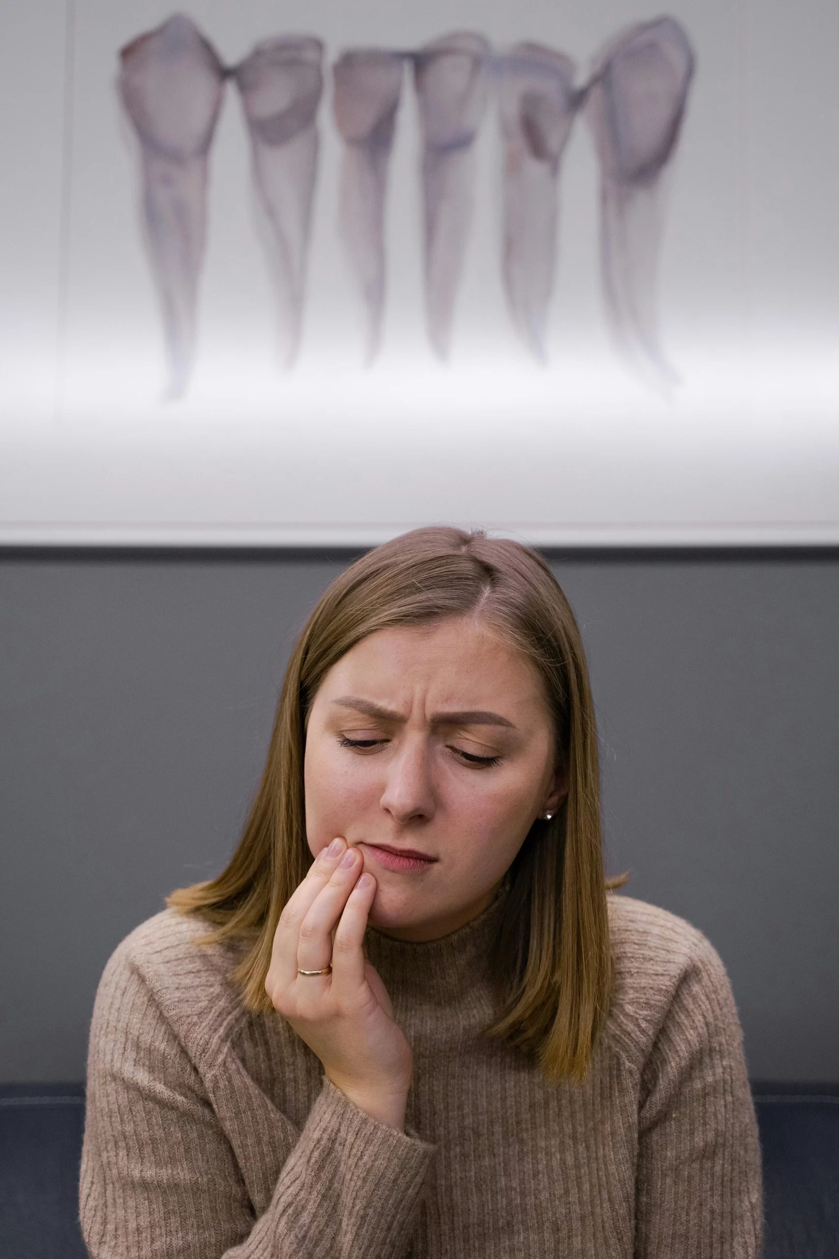 A woman in pain holding her cheek.